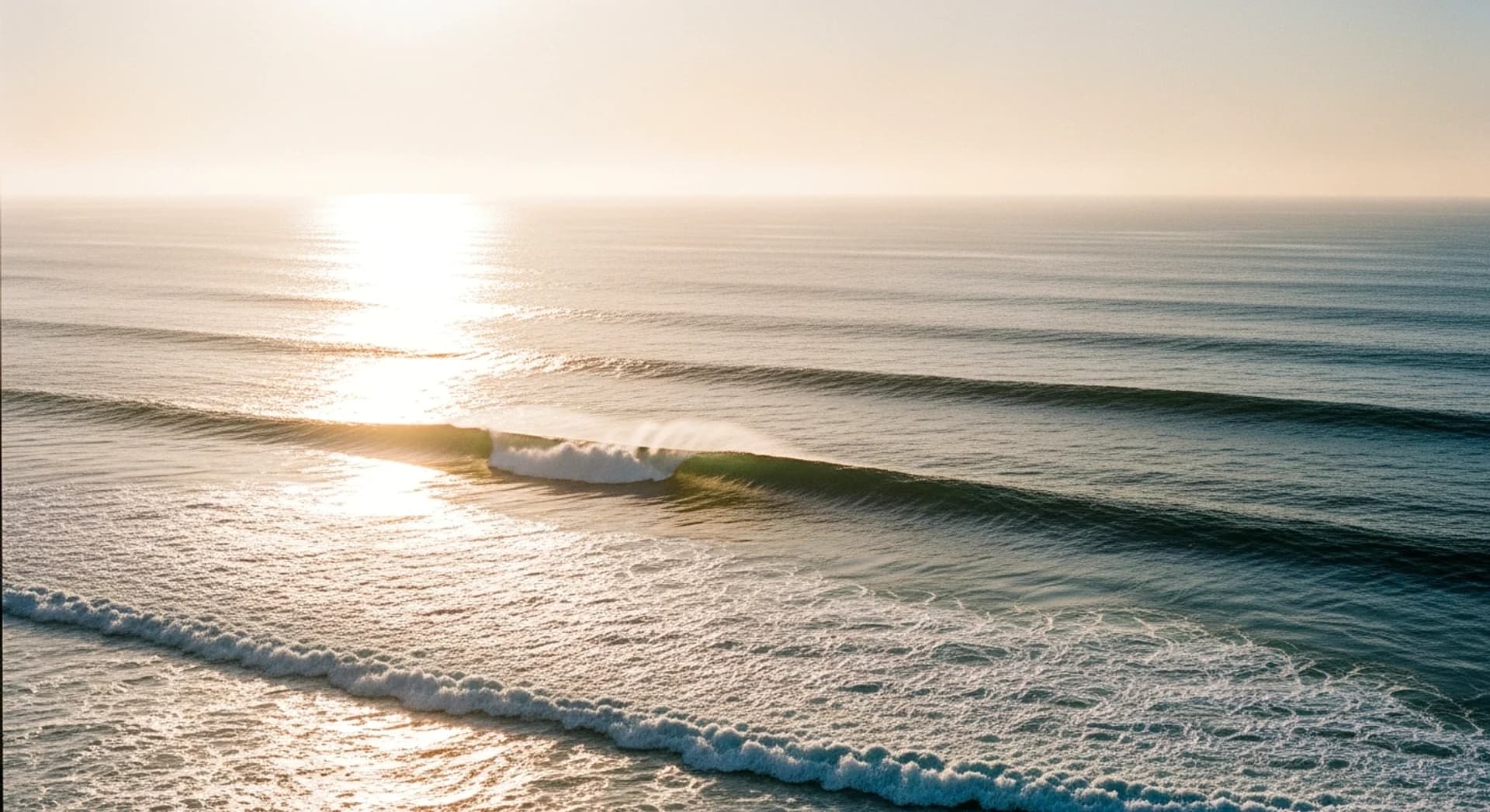Rolling Pacific Ocean waves at golden hour, sun glittering on the water